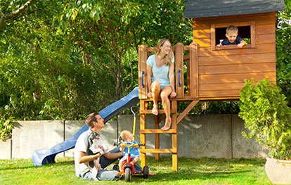 Spielhaus im Garten Baugenehmigung - Familie spielt auf Spielturm