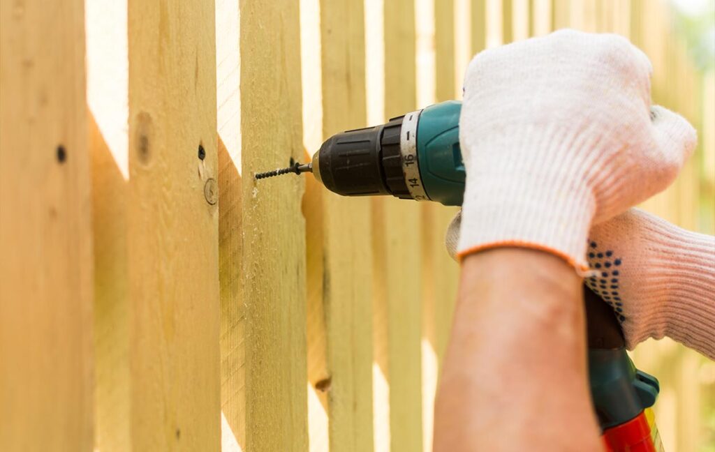 Zaun bauen - Latten werden mit Akku-Schraube befestigt